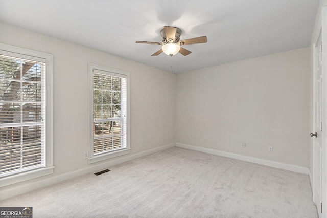 empty room featuring light carpet, ceiling fan, and baseboards