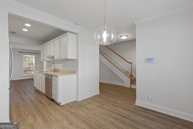 kitchen featuring stainless steel dishwasher, light wood-style flooring, white cabinetry, and baseboards