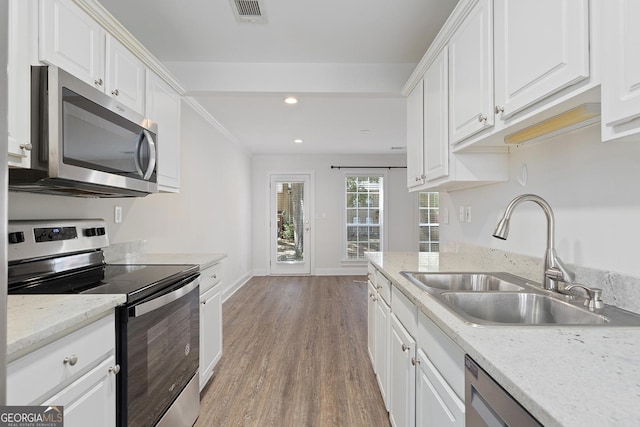 kitchen featuring appliances with stainless steel finishes, white cabinetry, a sink, and visible vents