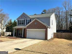 traditional-style house with concrete driveway, an attached garage, and fence