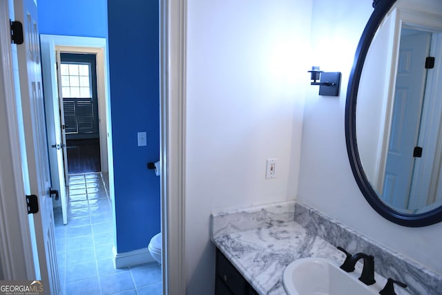 bathroom with toilet, tile patterned flooring, and vanity