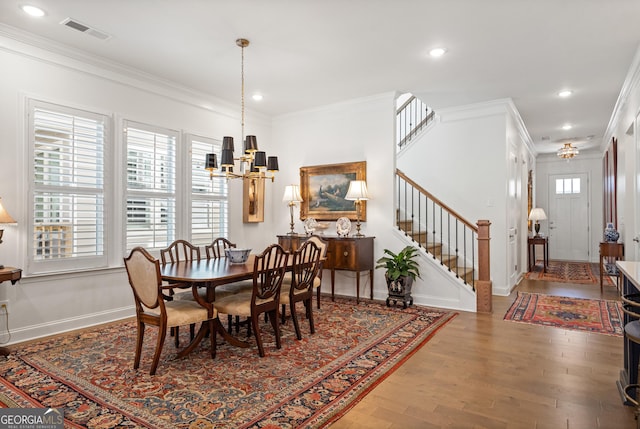 dining room featuring ornamental molding, stairway, and visible vents