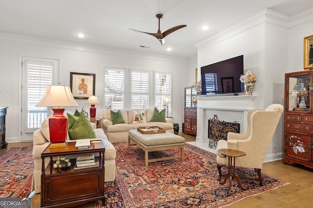 living room featuring ornamental molding, a healthy amount of sunlight, visible vents, and a fireplace