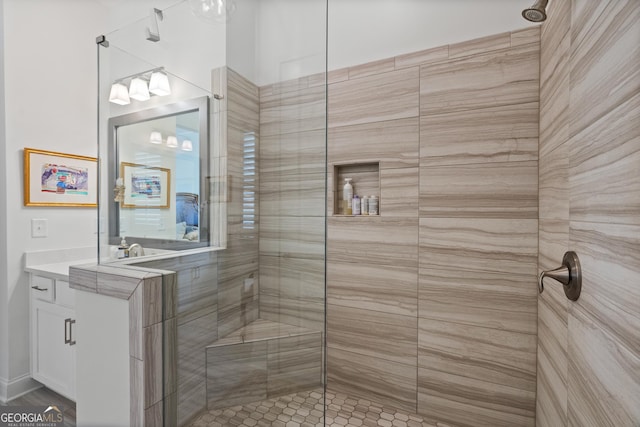 bathroom with tiled shower and vanity