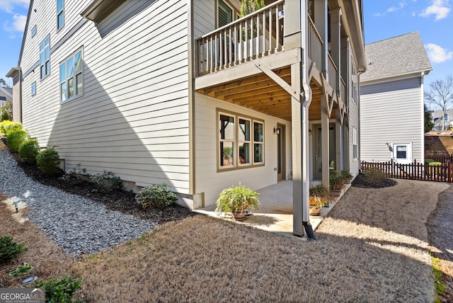 view of property exterior featuring a patio area and fence