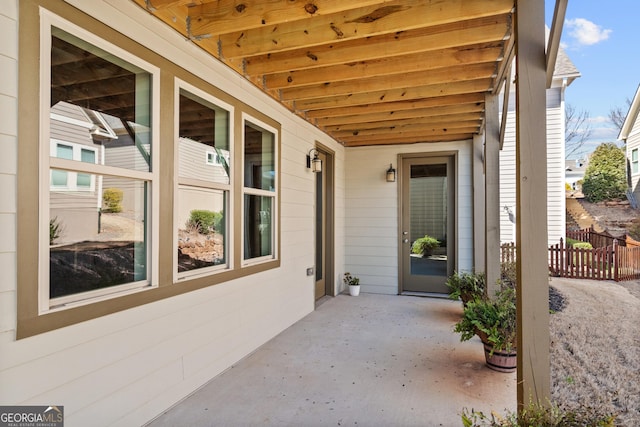 doorway to property featuring a patio area and fence