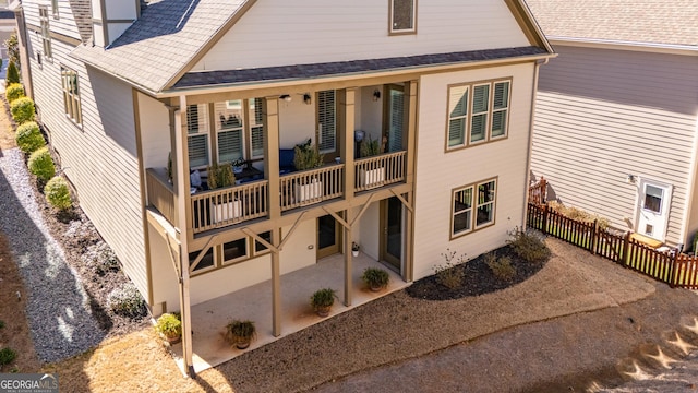 rear view of house featuring a patio and fence