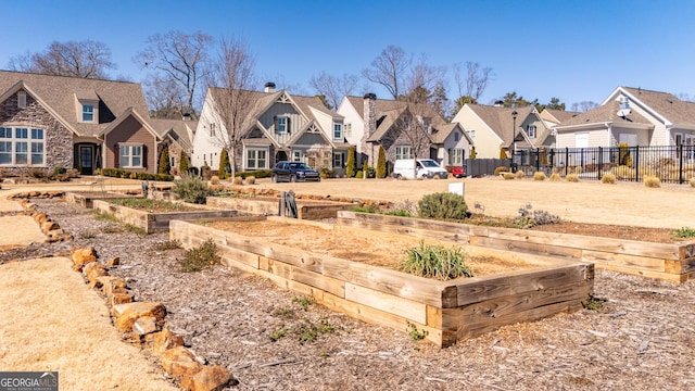 view of yard featuring a residential view, a vegetable garden, and fence