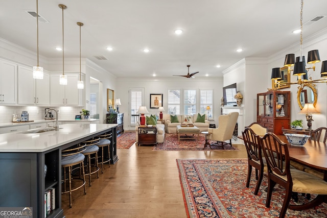 dining space with light wood-style flooring, recessed lighting, visible vents, and crown molding