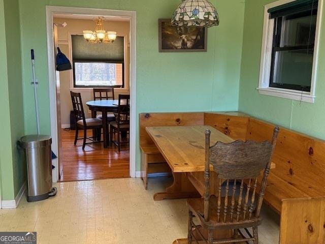 dining area featuring a chandelier, wood finished floors, and baseboards