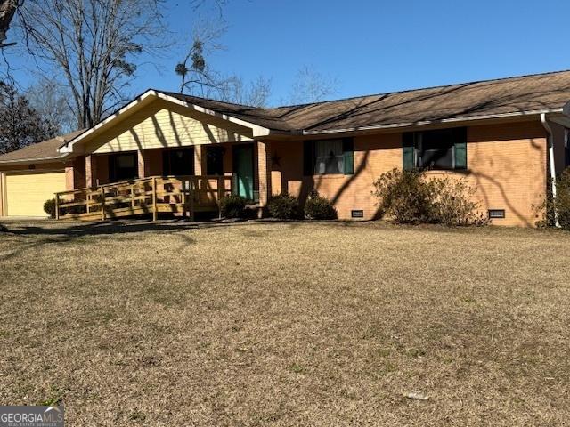 back of house featuring crawl space, an attached garage, and brick siding