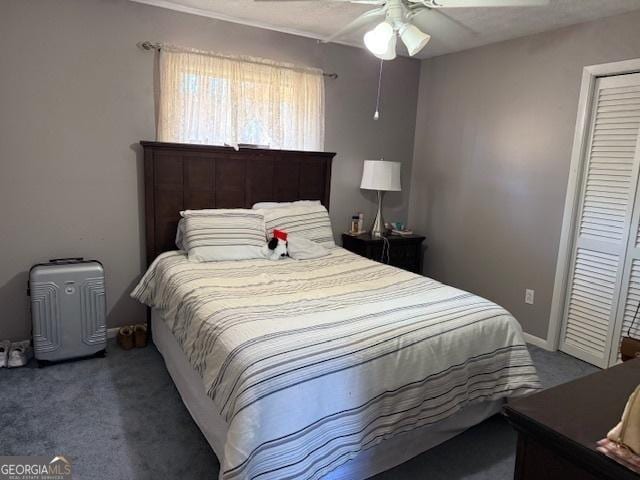 bedroom featuring a closet, dark carpet, a ceiling fan, and baseboards