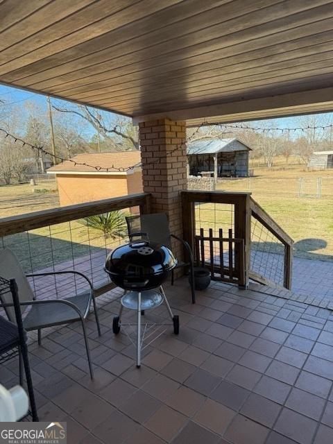 view of patio featuring a grill and a balcony