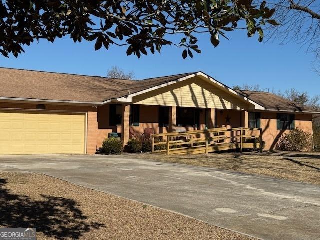 exterior space with a garage, concrete driveway, and brick siding