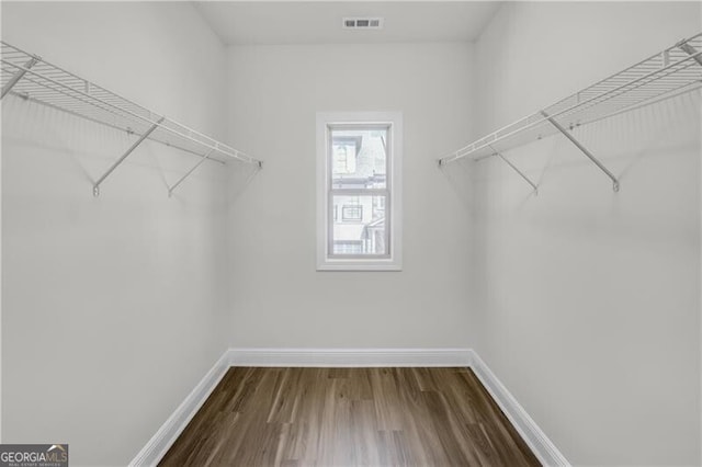 walk in closet with dark wood-style floors and visible vents