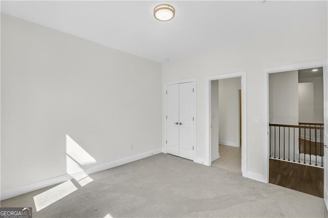 unfurnished bedroom with a closet, carpet flooring, and baseboards