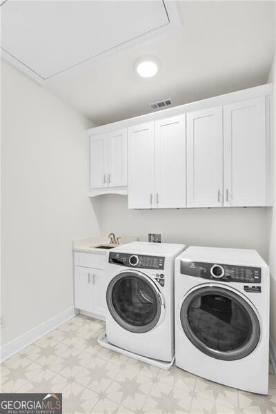 washroom with washer and dryer, cabinet space, visible vents, and light floors