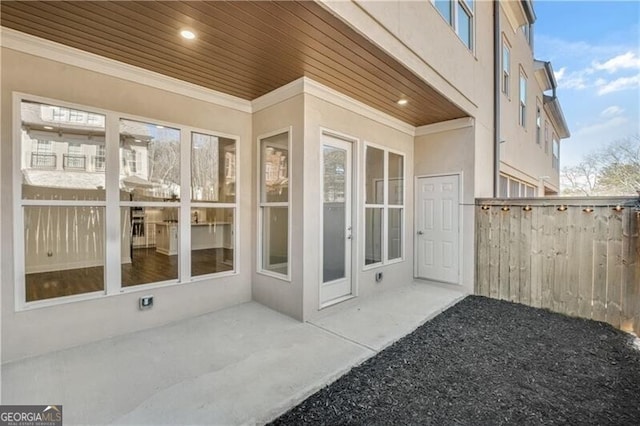 view of home's exterior with stucco siding, fence, and a patio