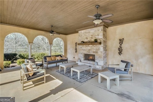 view of patio / terrace featuring an outdoor living space with a fireplace and a ceiling fan