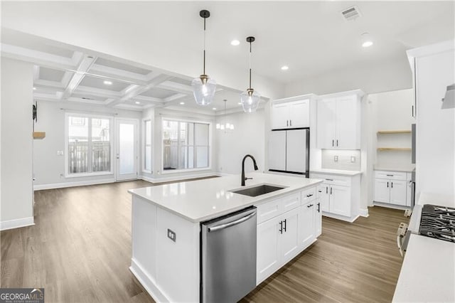 kitchen featuring coffered ceiling, wood finished floors, freestanding refrigerator, stainless steel dishwasher, and a sink