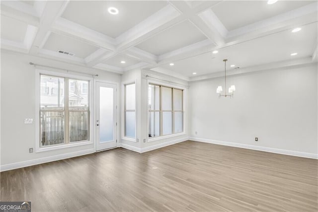 interior space with visible vents, baseboards, coffered ceiling, and wood finished floors