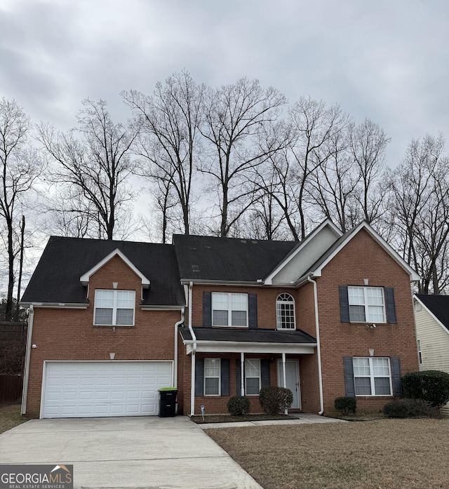 traditional-style house featuring concrete driveway, brick siding, and an attached garage