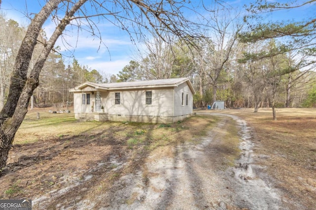 view of front of house featuring crawl space, dirt driveway, and metal roof