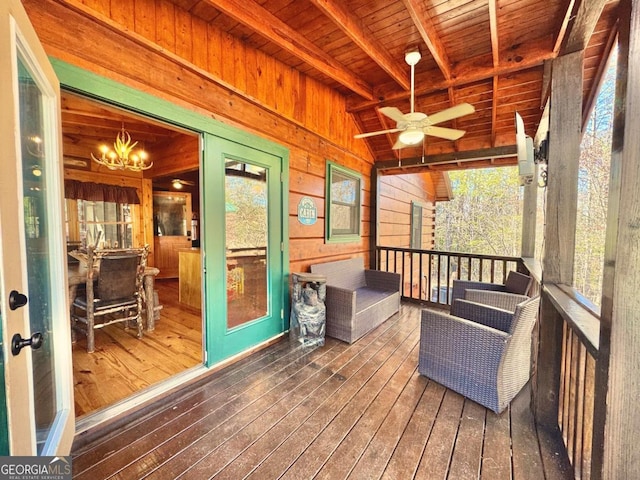 sunroom featuring vaulted ceiling with beams, wood ceiling, and ceiling fan with notable chandelier