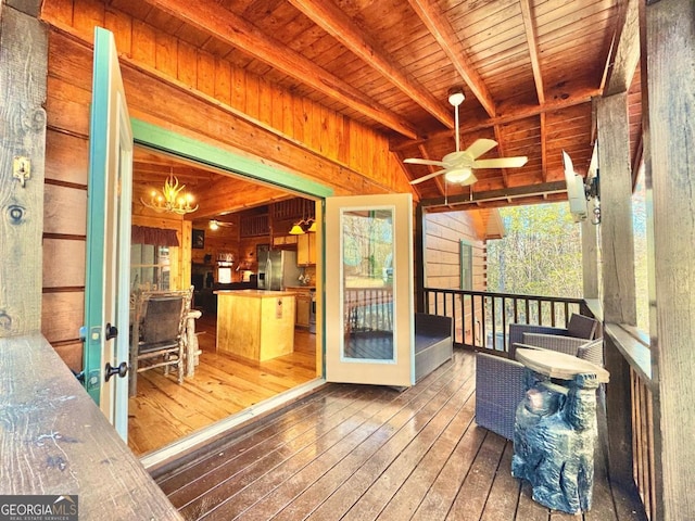 unfurnished sunroom with ceiling fan with notable chandelier, beamed ceiling, and wooden ceiling