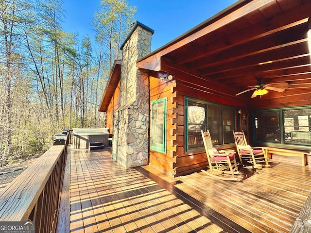 wooden deck with ceiling fan and a hot tub