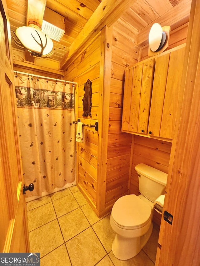 bathroom featuring visible vents, toilet, wood ceiling, wooden walls, and tile patterned floors