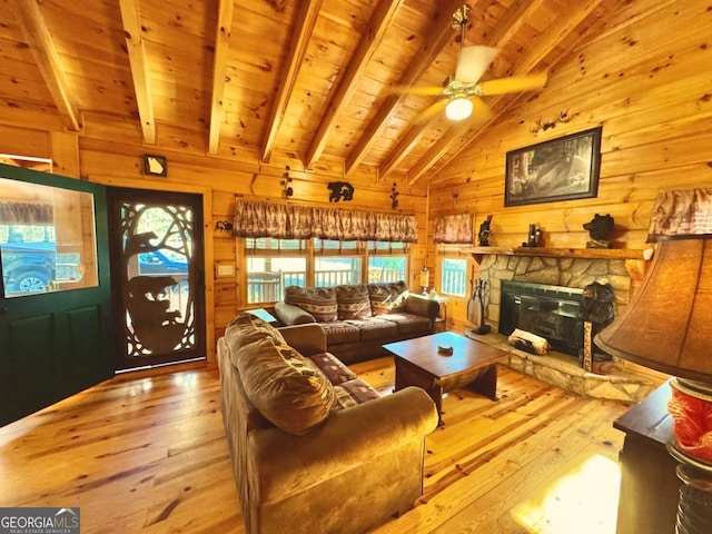 living area featuring vaulted ceiling with beams, wood walls, wooden ceiling, and light wood-style floors