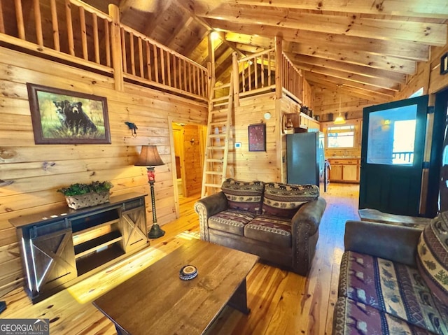 living area with light wood-style floors, high vaulted ceiling, and wooden walls