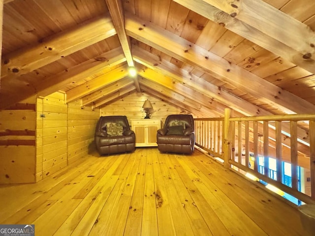 unfurnished room featuring vaulted ceiling with beams, light wood-style flooring, wooden walls, and wood ceiling