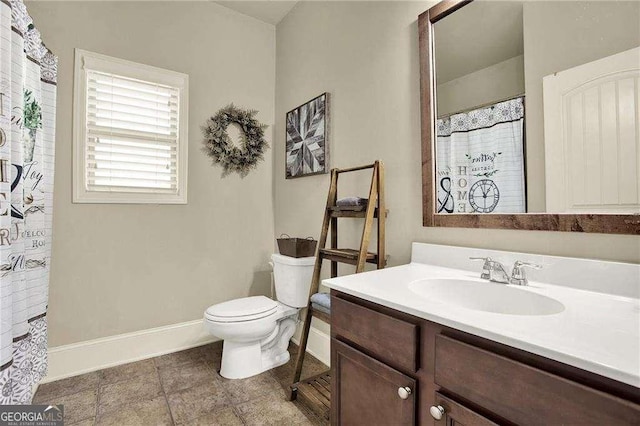 bathroom featuring a shower with curtain, baseboards, vanity, and toilet