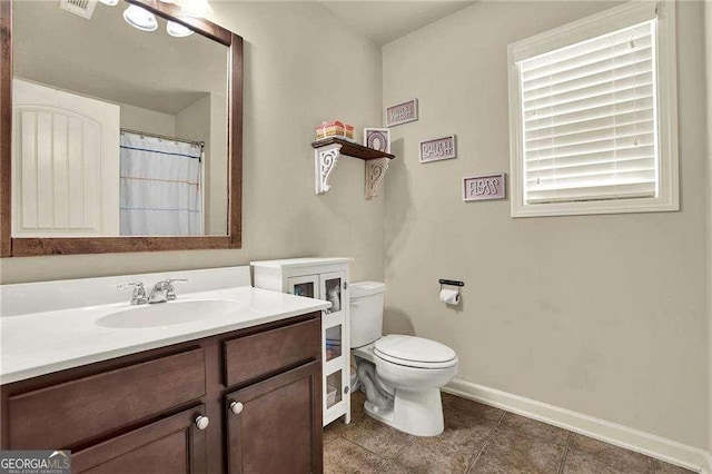 full bath featuring baseboards, vanity, and toilet