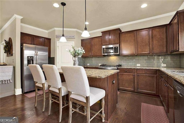 kitchen featuring light stone countertops, stainless steel appliances, dark wood finished floors, and a center island