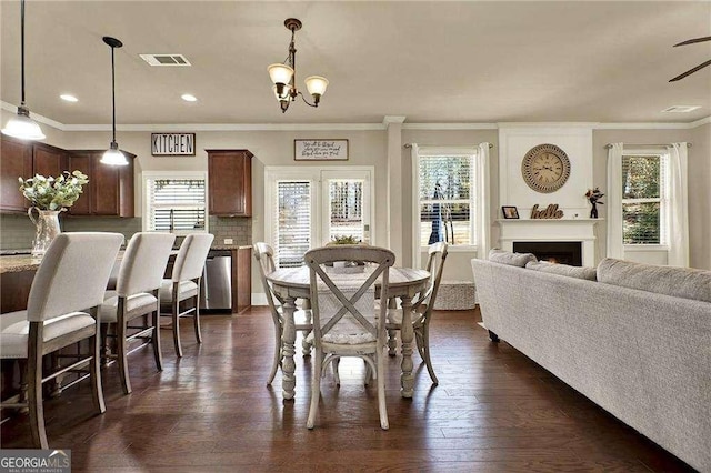 dining room featuring a lit fireplace, plenty of natural light, dark wood finished floors, and visible vents