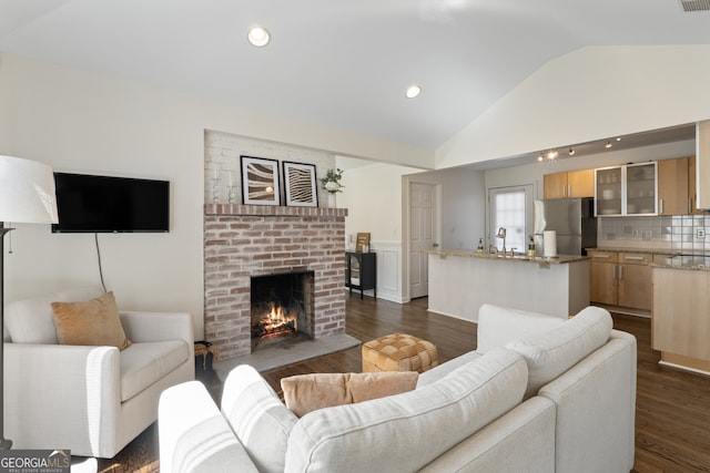 living room with dark wood-style floors, a fireplace, lofted ceiling, recessed lighting, and visible vents