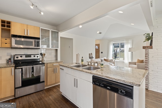 kitchen with a center island with sink, stainless steel appliances, light brown cabinetry, dark wood-type flooring, and glass insert cabinets