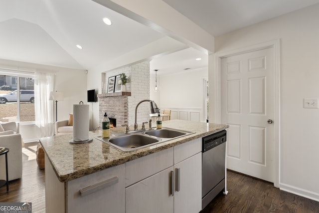 kitchen featuring dark wood-style floors, a kitchen island with sink, vaulted ceiling, a sink, and dishwasher