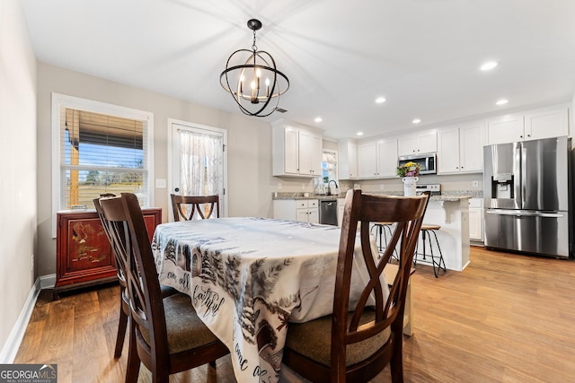 dining space with a chandelier, recessed lighting, baseboards, and light wood finished floors