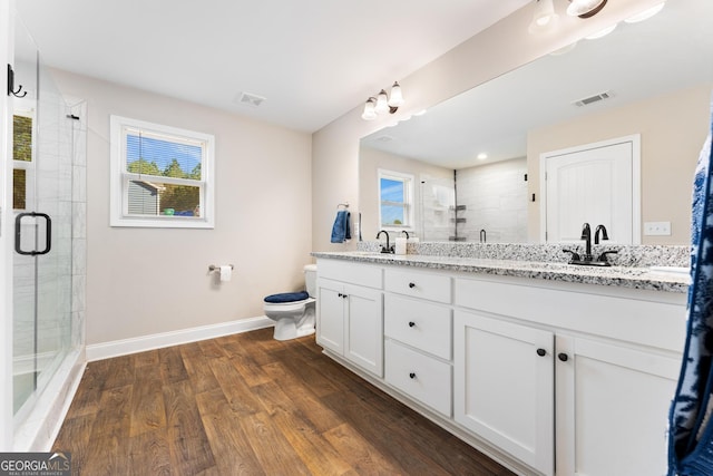 full bathroom with a stall shower, plenty of natural light, visible vents, and wood finished floors