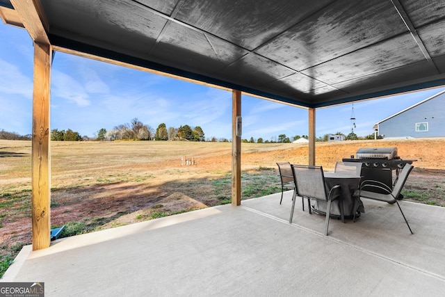 view of patio / terrace featuring a rural view, grilling area, and outdoor dining space