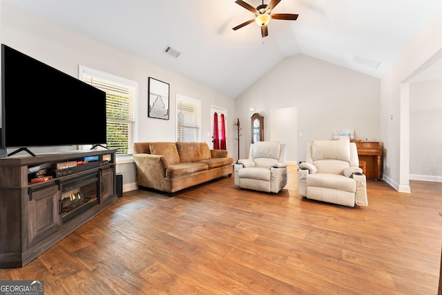 living area with baseboards, a ceiling fan, visible vents, and light wood-style floors