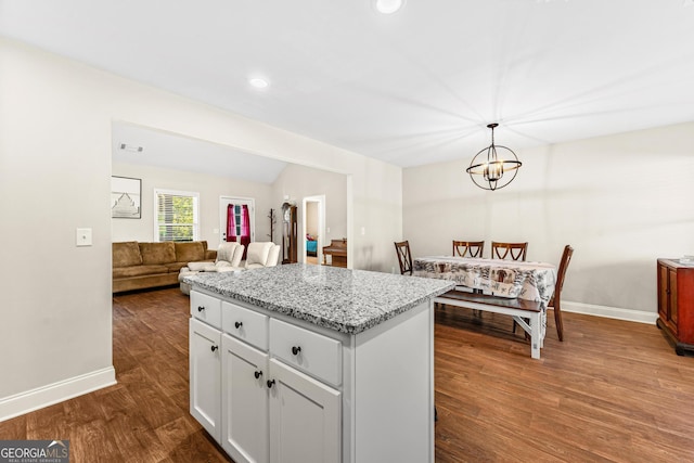 kitchen with lofted ceiling, dark wood-style flooring, white cabinetry, and baseboards