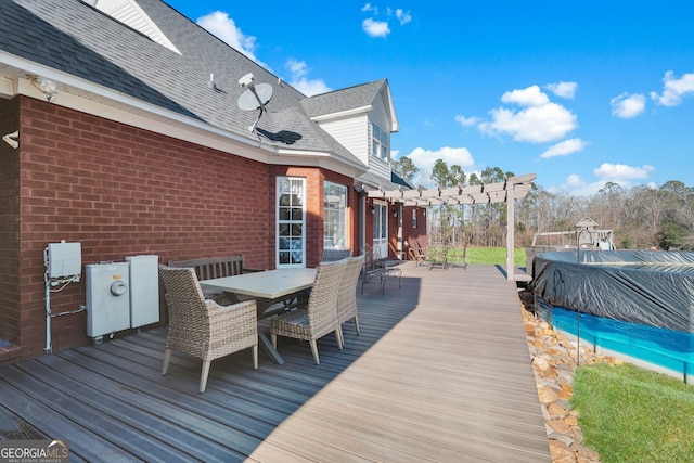 wooden terrace featuring outdoor dining area, a covered pool, and a pergola