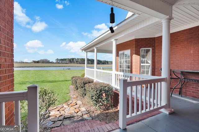 view of yard with a porch and a water view