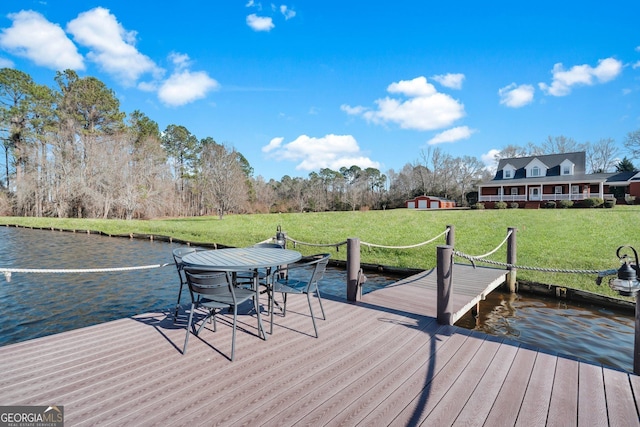 view of dock featuring a water view and a yard