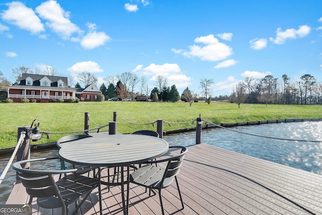 dock area featuring outdoor dining area and a lawn